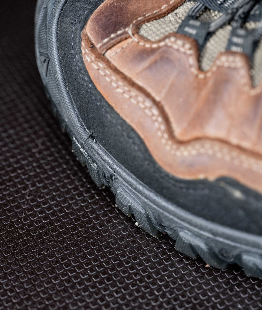 Close-up of hiking boot on textured mat.